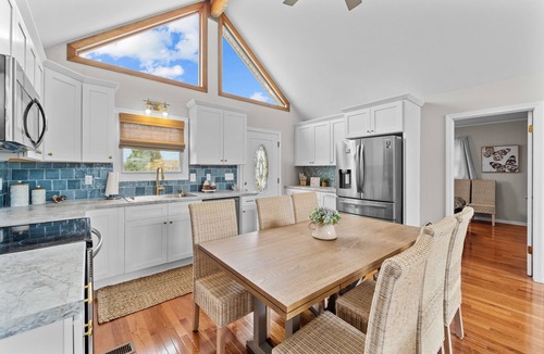 Colington Harbour House | Dog-friendly home with canal views, dock, kayaks, sunroom, deck, & firepit